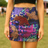High-waisted fitted mini skirt featuring a vibrant tiger print in rainbow colors over a blue and purple camouflage background. The skirt includes a 1.5” elastic waistband and is made of eco polyester and spandex. Pencil fit hugs the body with a smooth silhouette. Available in performance or glitter finish, sizes S to XL.